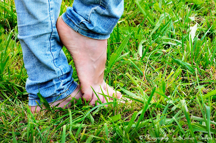 Nackte Füße. Frauenfüße im Gras. Barfuß gehen ist sehr gesund. Fotografie von Lothar Seifert