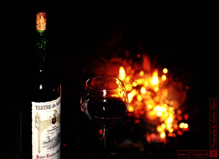 Feiern mit einem Glas Rotwein am Lagerfeuer. Fotografie von Lothar Seifert