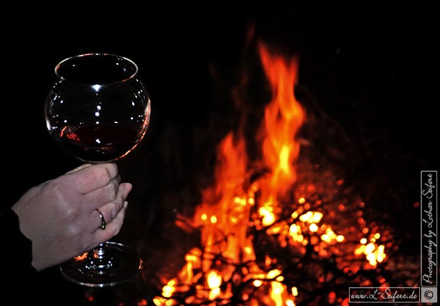 Rotwein, ein Glas unter freiem Himmel am Feuer. Fotografie von Lothar Seifert