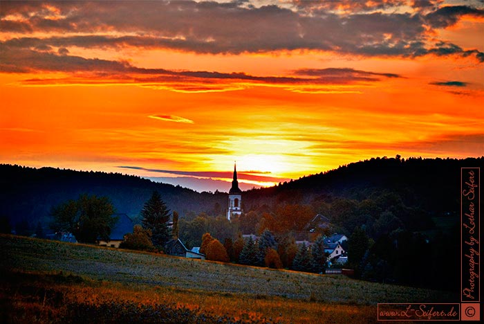 Wehrsdorf mit der Kirche. Sonnenunergang in der Oberlausitz. Fotografie von Lothar Seifert