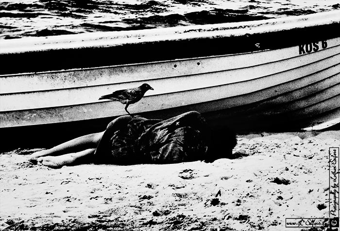 Tote Frau am Strand liegt hinter einem Boot. Fotografie von Lothar Seifert