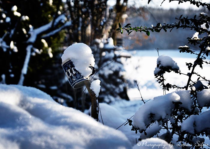 Bierkrug, vergessen und begraben unterm Schnee. Fotografie von Lothar Seifert