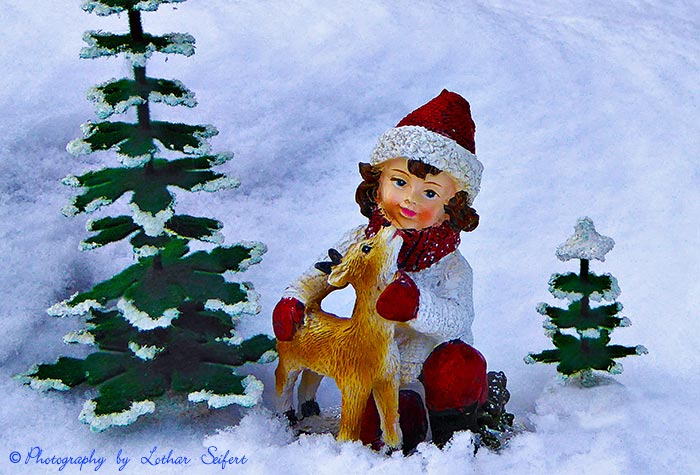 Winter, ein Mädchen und ein Reh im Schnee. Fotografie von Lothar Seifert